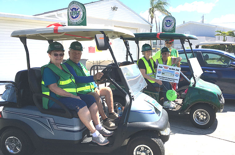 CERT golf carts with emblems on top circulate the community